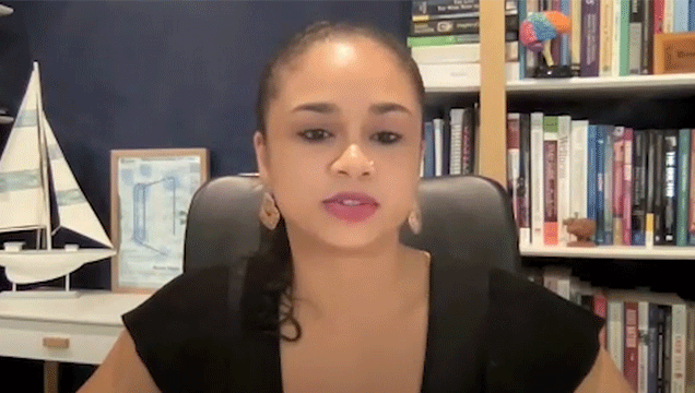 Dr Annabelle Nankoo sits in her study in front of a bookshelf and with a boat on display.